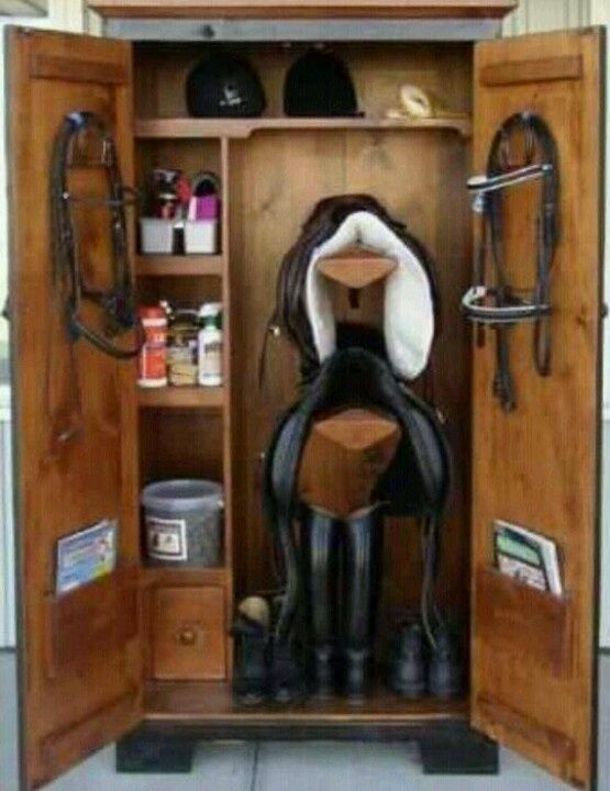 Armoire en bois ouverte contenant du matériel d'équitation.