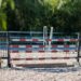 Obstacle d’équitation composé de barres rouges et blanches dans une carrière